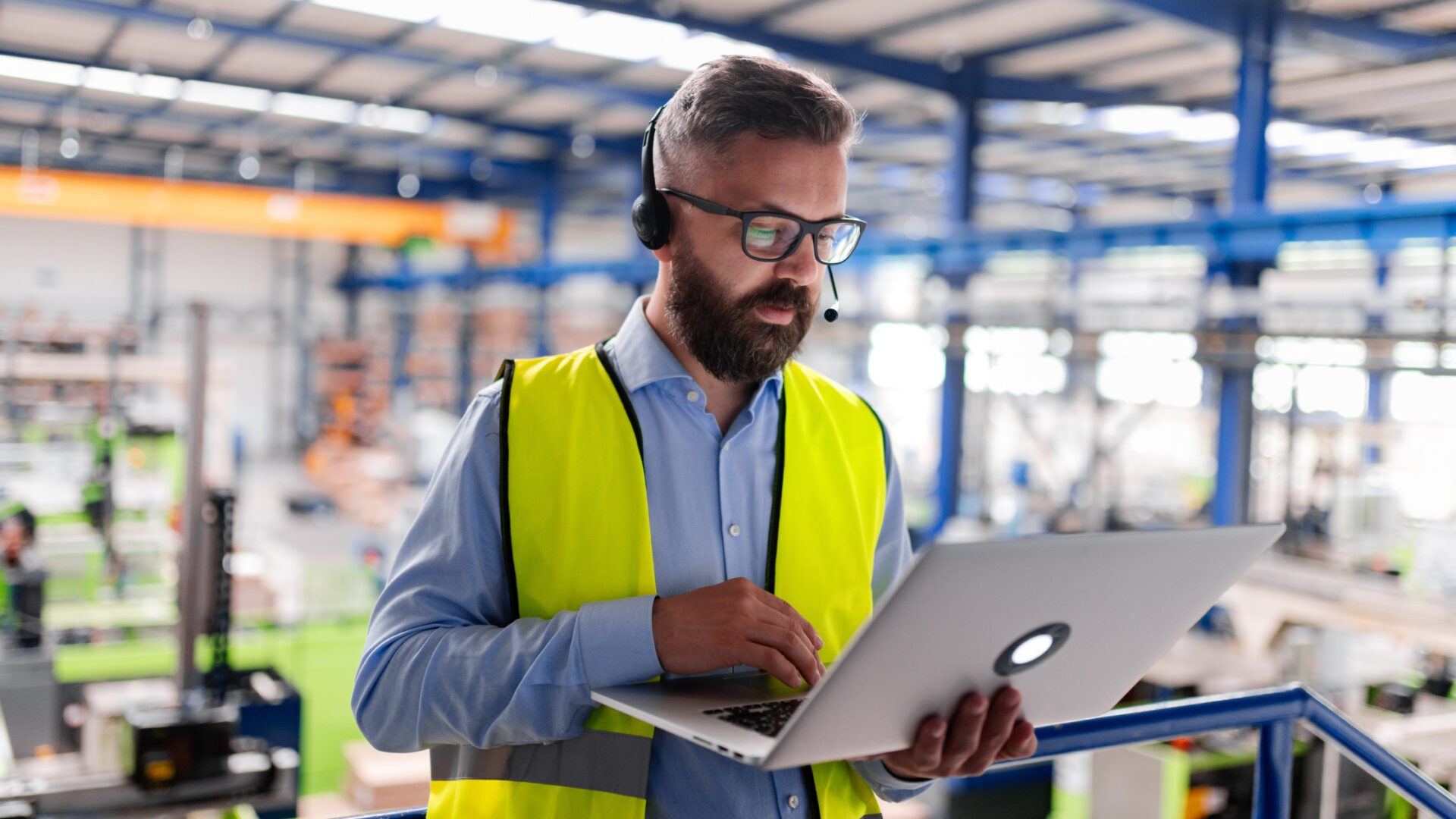 Ingeniero revisando panel de control industrial con alarmas activas en planta de manufactura