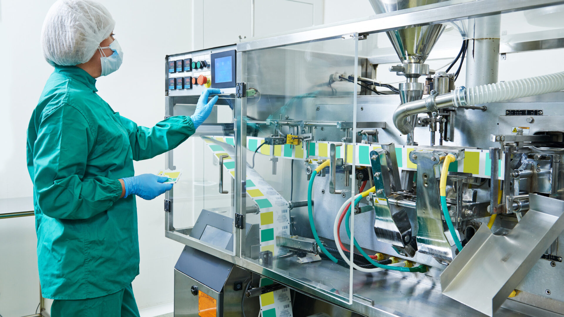 Operador supervisando una línea automatizada de producción farmacéutica con sistema de control industrial, representando la automatización, el uso de SCADA, la captura de datos en origen y el cumplimiento de las Buenas Prácticas de Manufactura (BPF).
